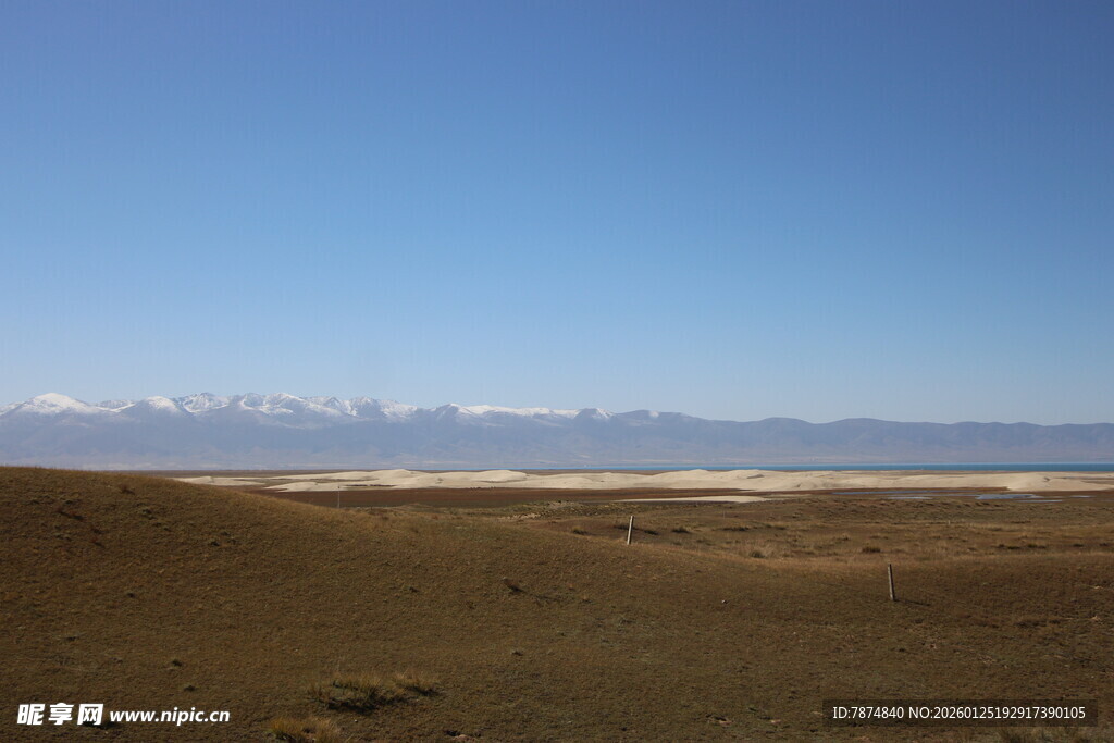 广阔荒漠与远处蓝天雪山
