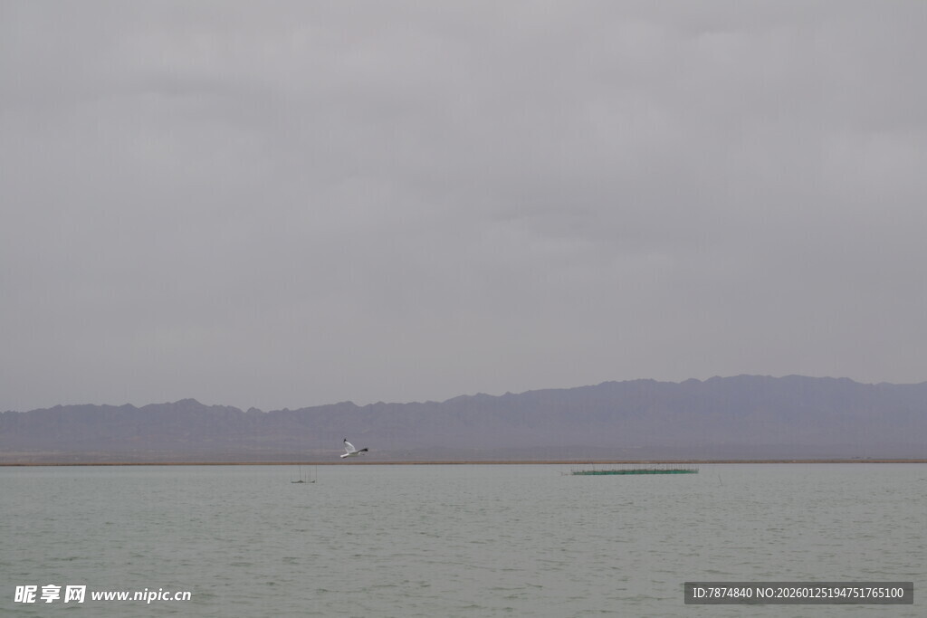 阴天的平静湖面与远山