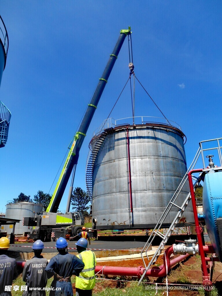工人操作起重机安装储水罐