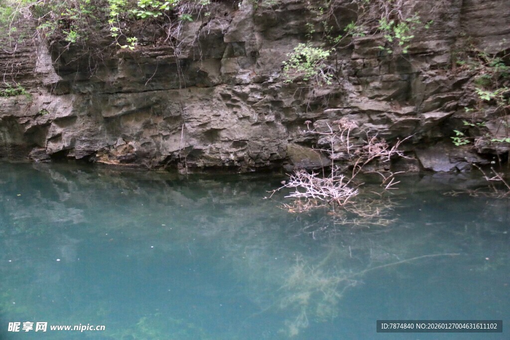 清澈潭水旁的嶙峋岩壁