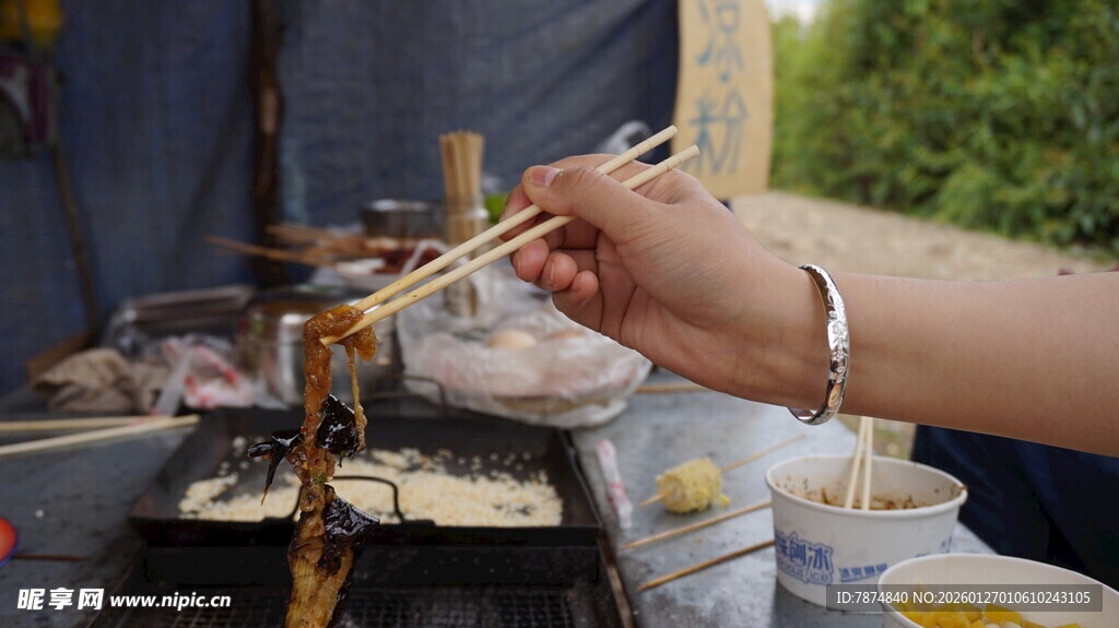 手持筷子享用户外美食