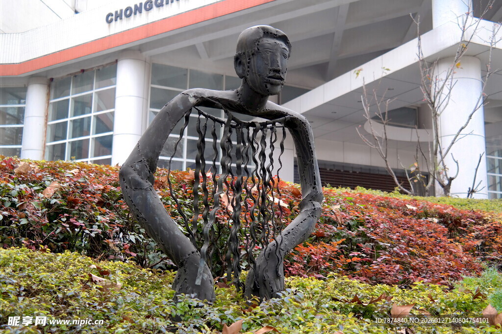 镂空人物雕塑位于绿植旁