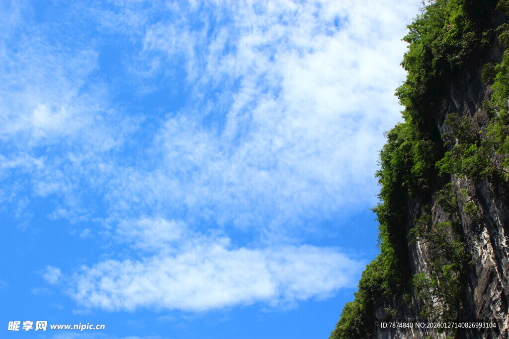 蓝天白云下的陡峭山壁