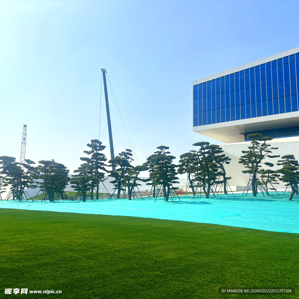 现代建筑旁的翠绿草坪与水池