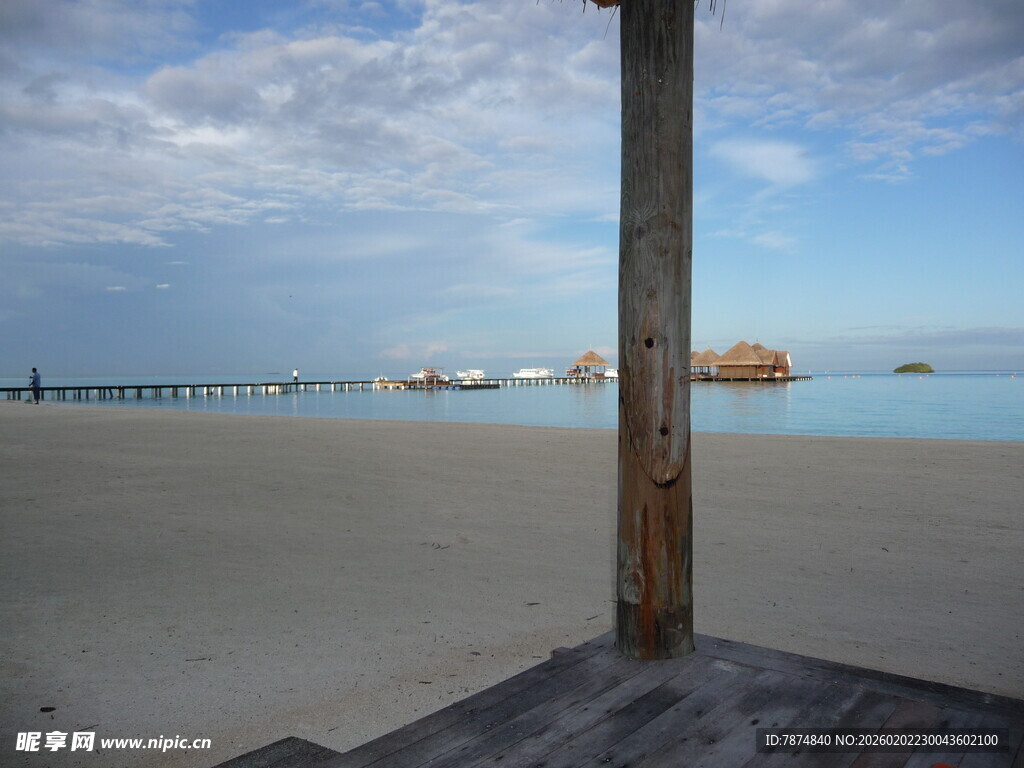 海边木柱旁的开阔沙滩景色