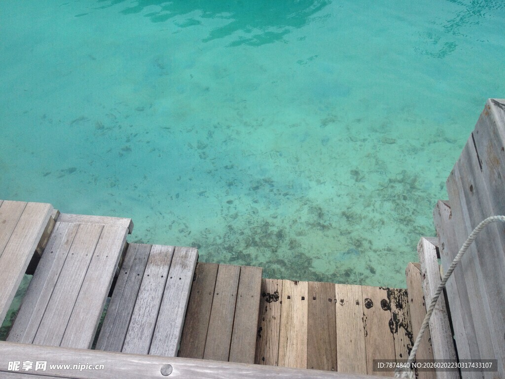 木质阶梯通向清澈海水
