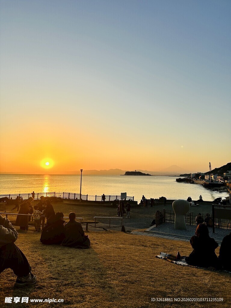 夕阳下沙滩上的休闲人群