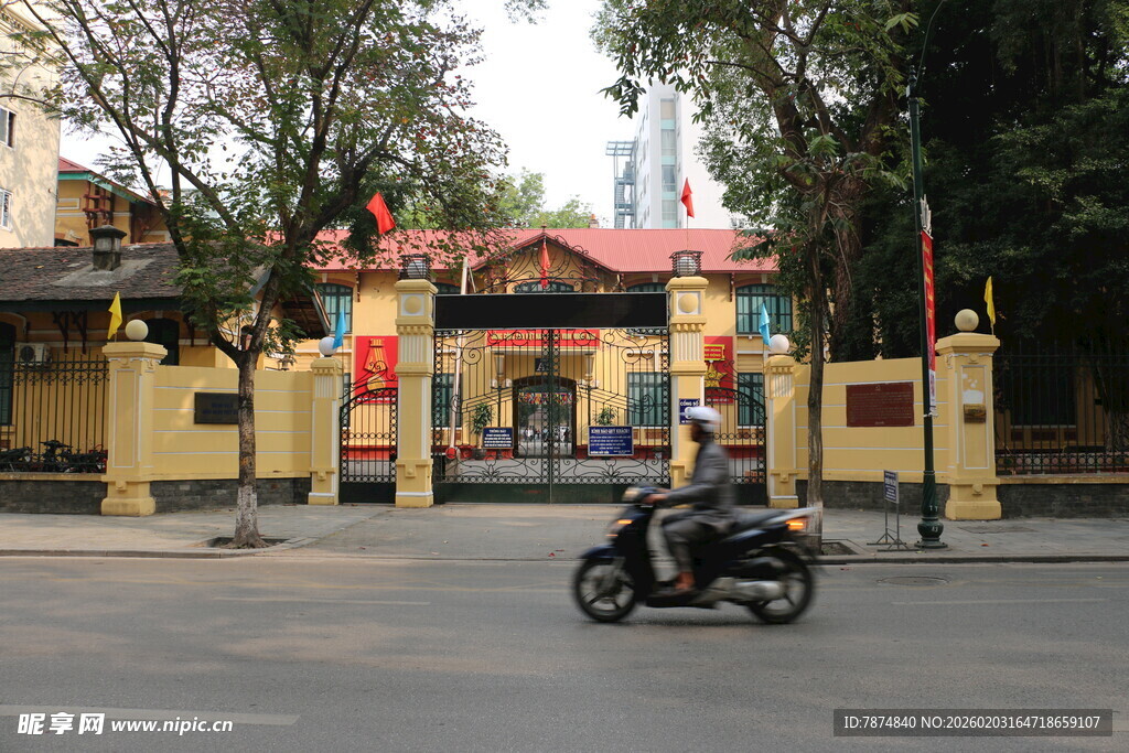越南骑摩托经过的黄色建筑大门