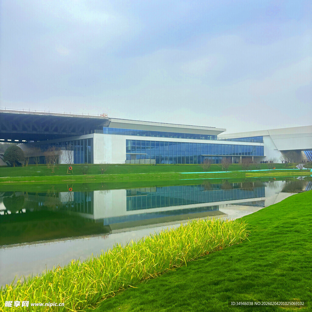 现代建筑旁的碧水绿草景观