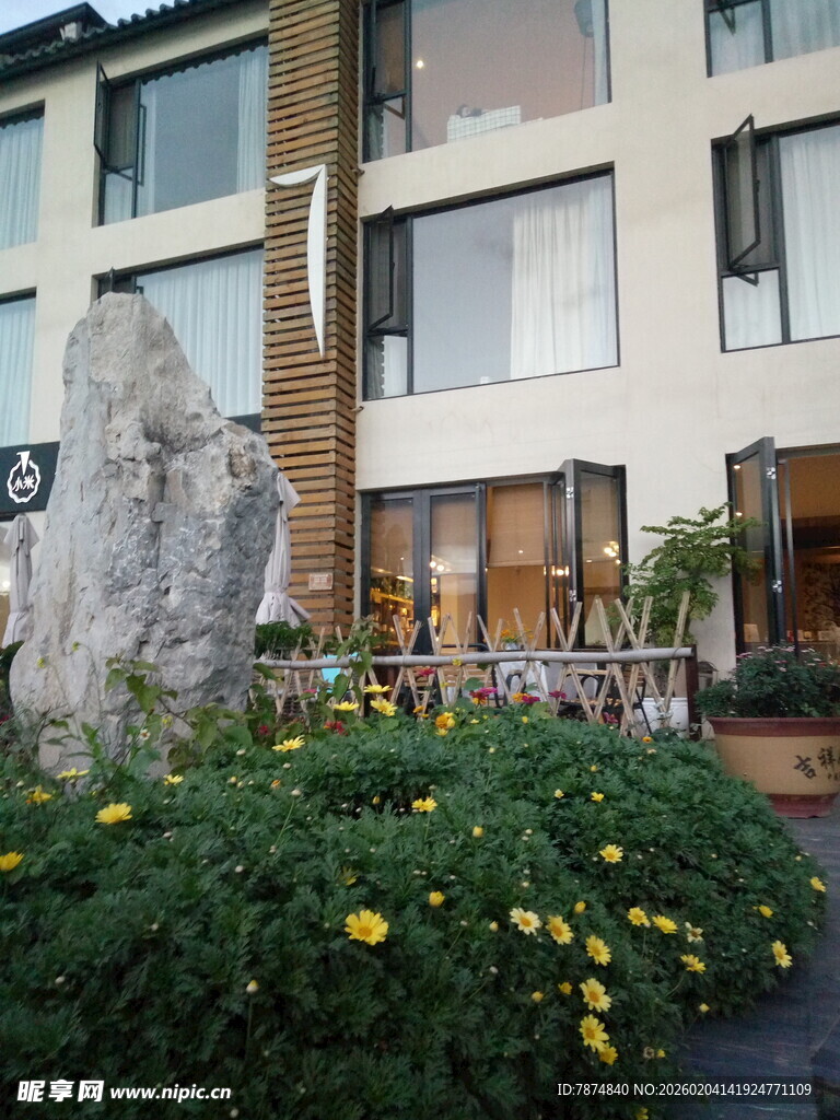 现代建筑前的花卉与石雕景观