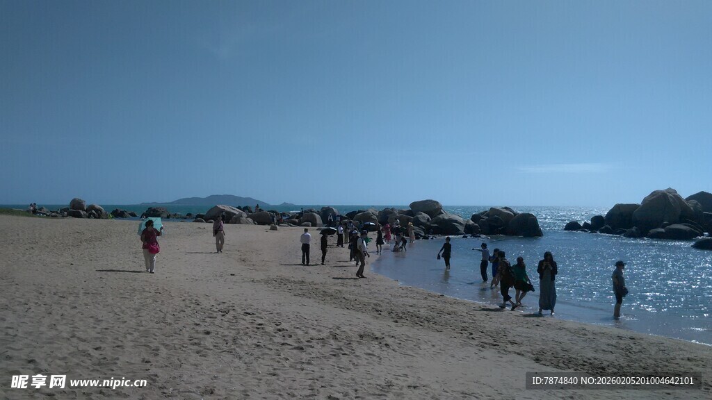 三亚热闹海滩上的休闲人群