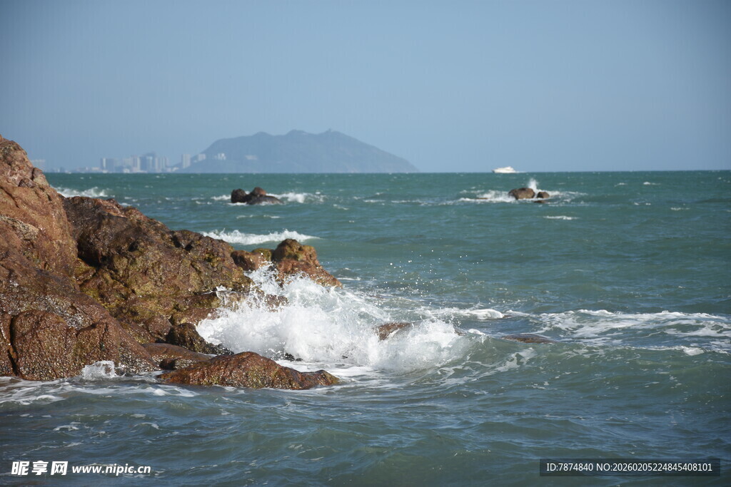 三亚海边礁石与海上船只景象