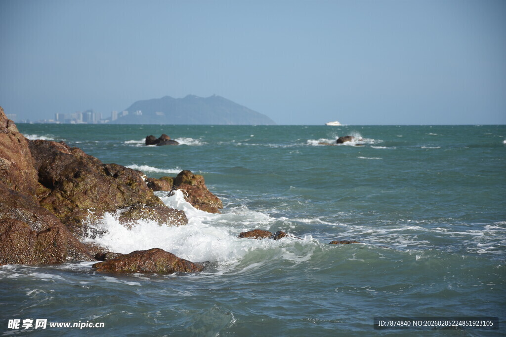 三亚海边礁石与海上船只景象