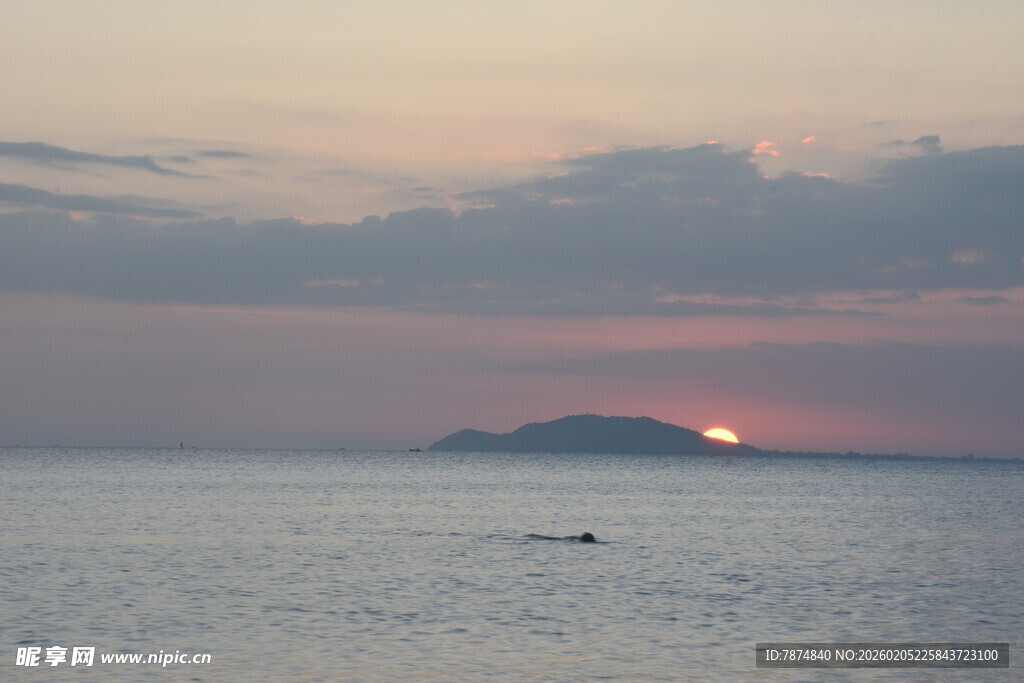 三亚海上日落时的孤舟远景