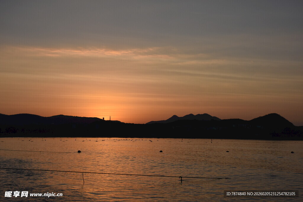 三亚夕阳下的宁静水面与远山