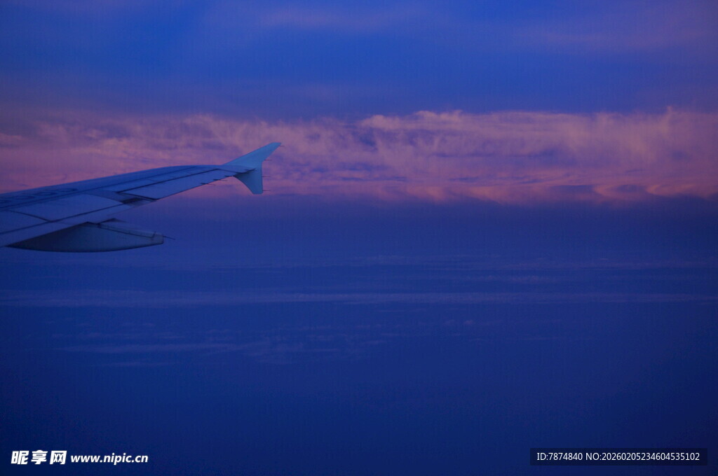 三亚黄昏下翱翔于天际的飞机