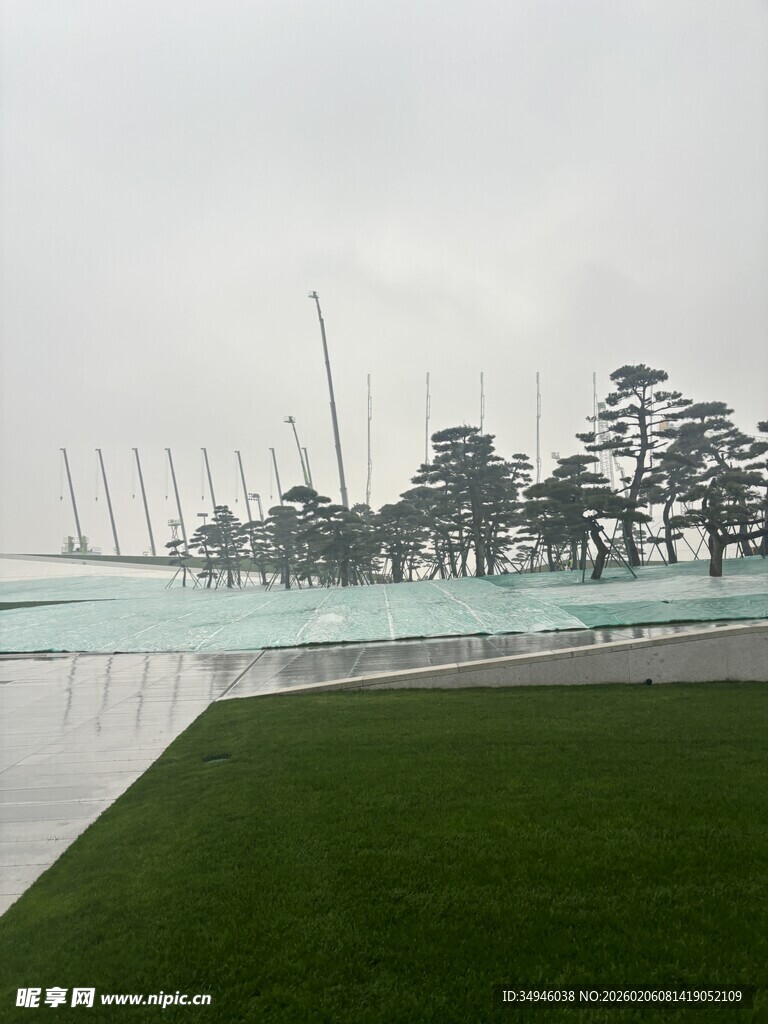 湖边绿树与远处林立桅杆