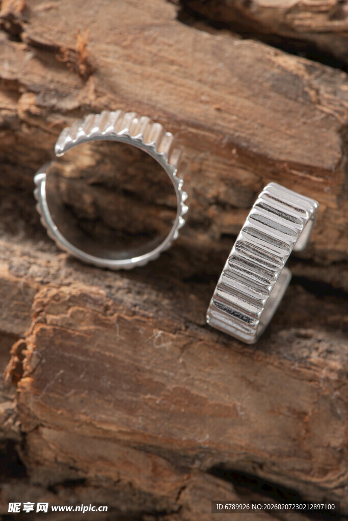 钻石戒指与银饰置于木上