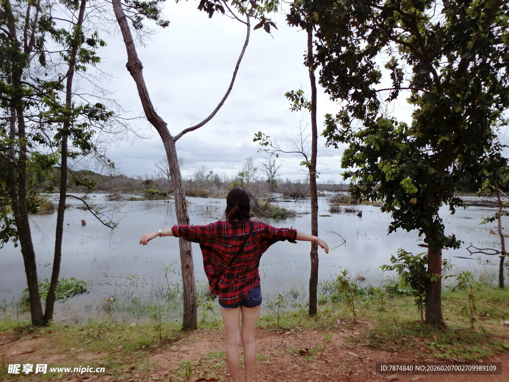 湖畔伸展双臂的红衣女子