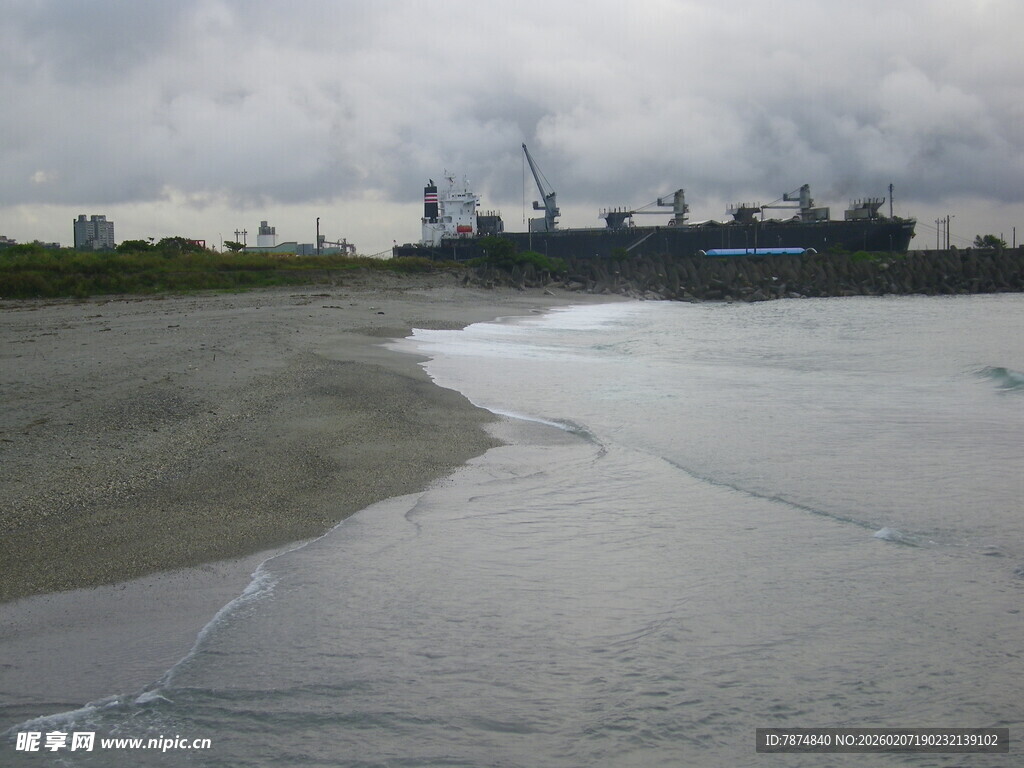 阴天海边与远处工业景象