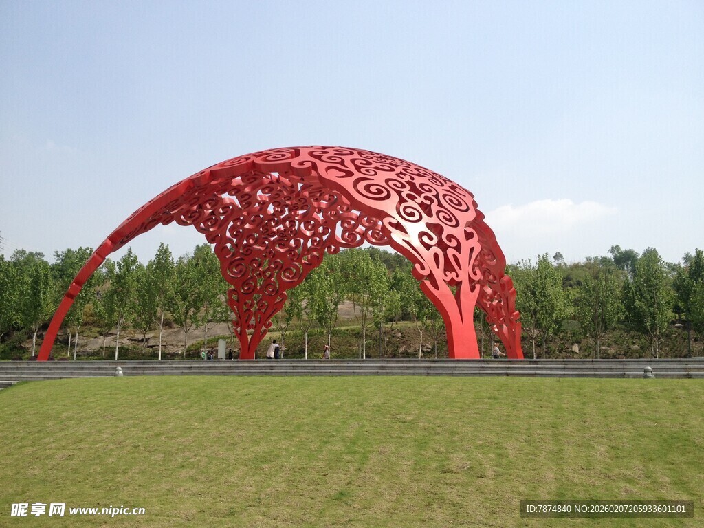 红色镂空拱形雕塑于草地
