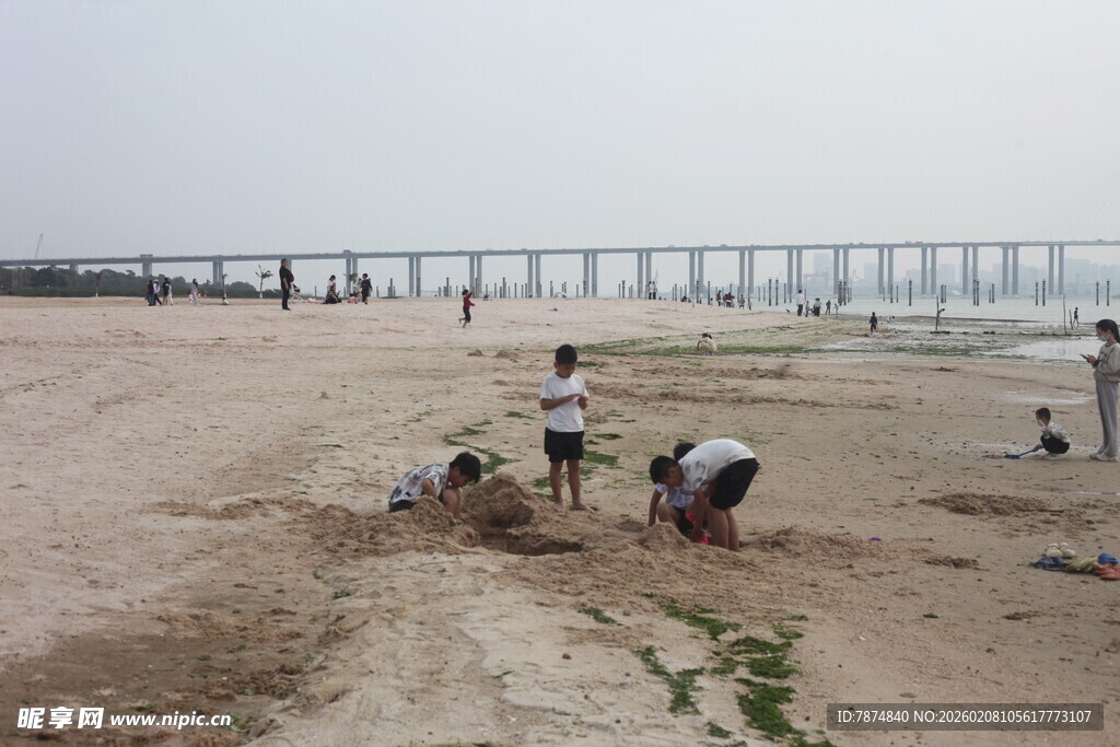 湛江沙滩上的人们与远处栈桥