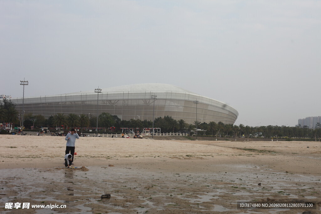 湛江沙滩上的人及远处体育场