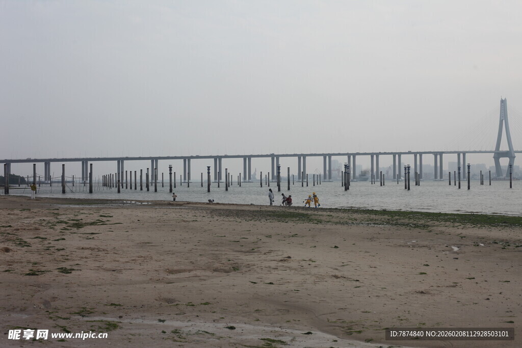 湛江海边长桥与沙滩上的行人