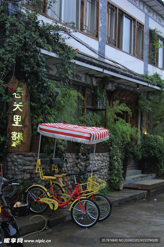 复古三轮车停靠在绿植建筑旁