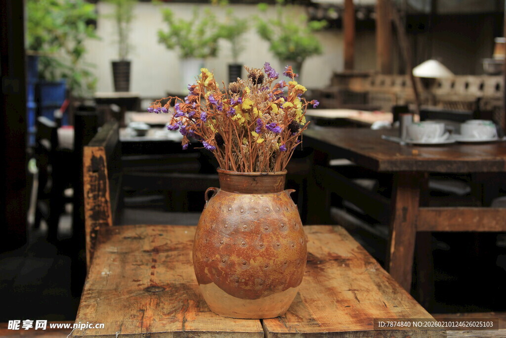 古朴陶罐插繁花于木桌