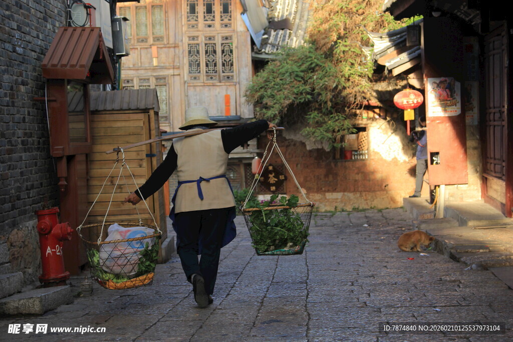 小巷中背着背篓的行人