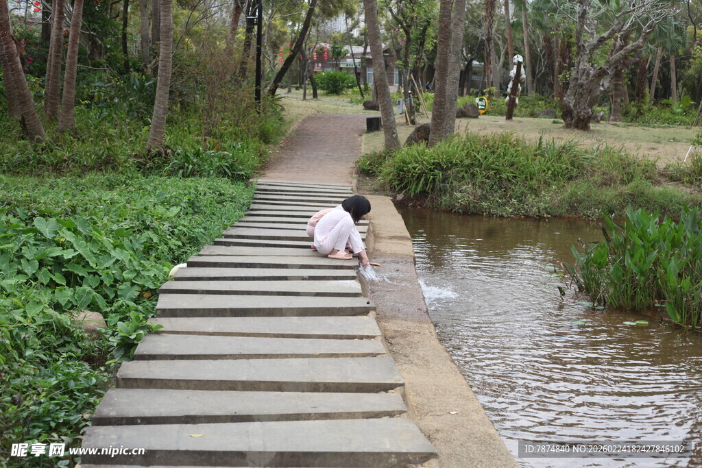 木栈道上的人俯身看水边