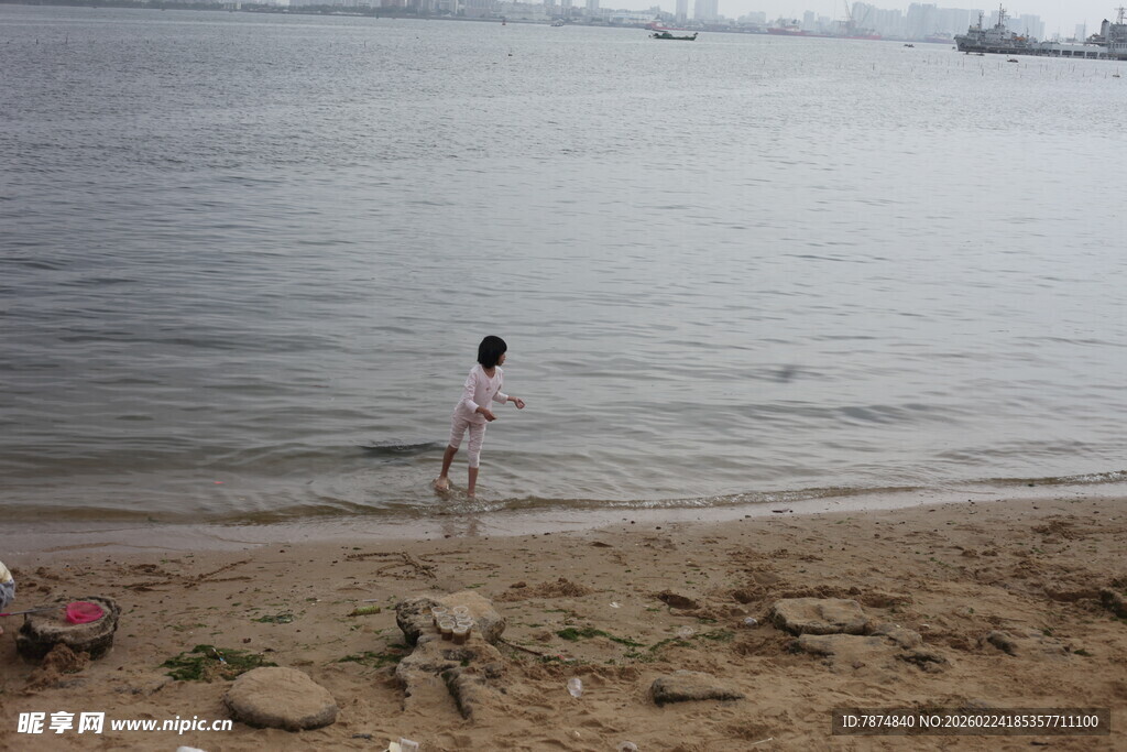 女孩于水边沙滩嬉戏