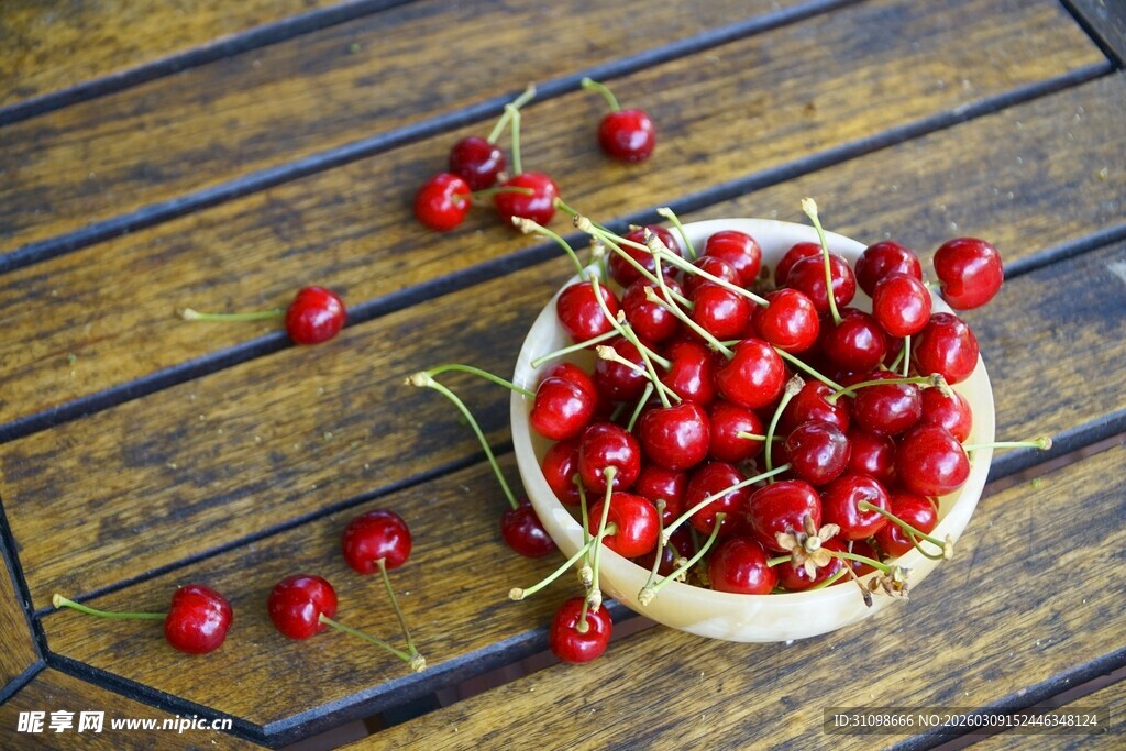 木桌上碗装新鲜红樱桃