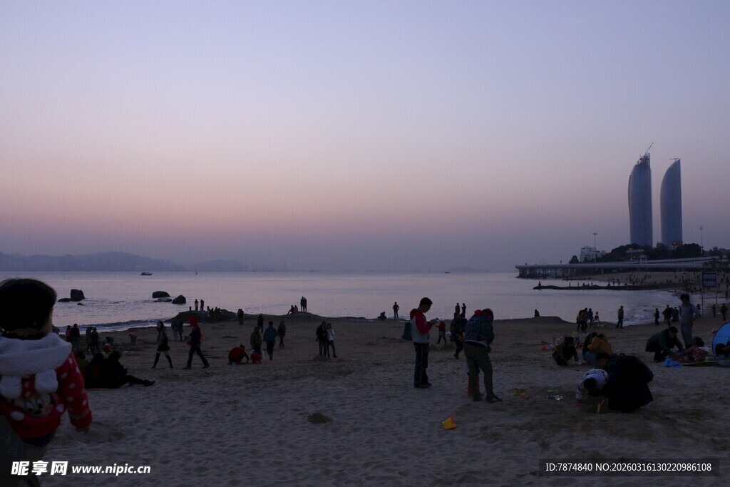 黄昏海滩上的休闲人群