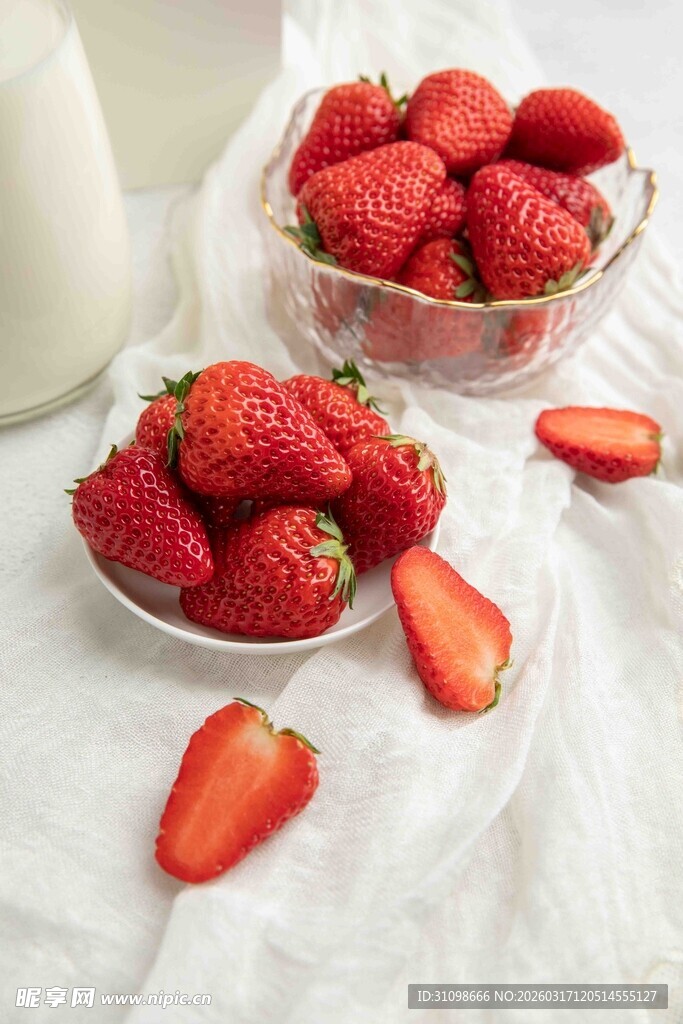 新鲜草莓摆放在白色桌布上