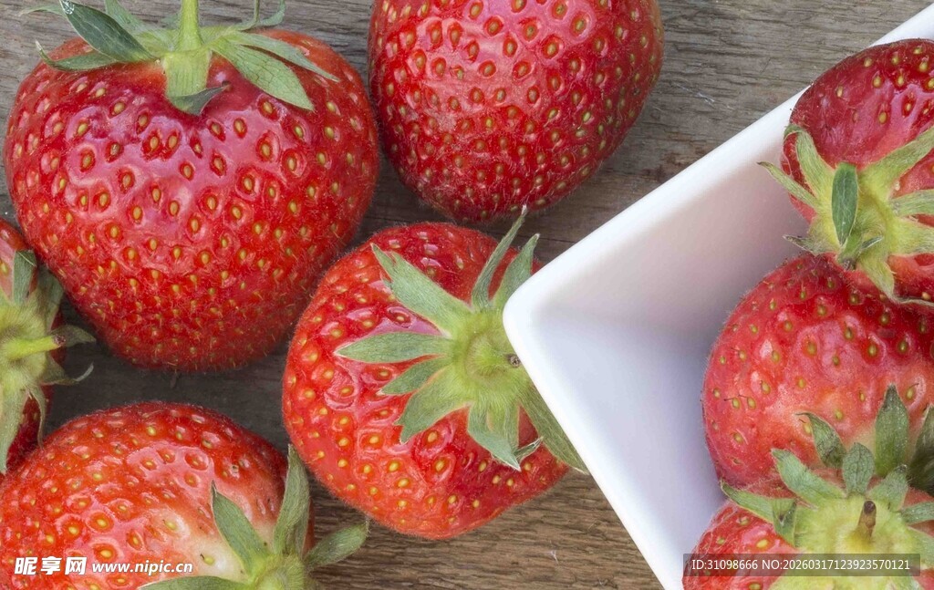 新鲜诱人的草莓摆放在木桌