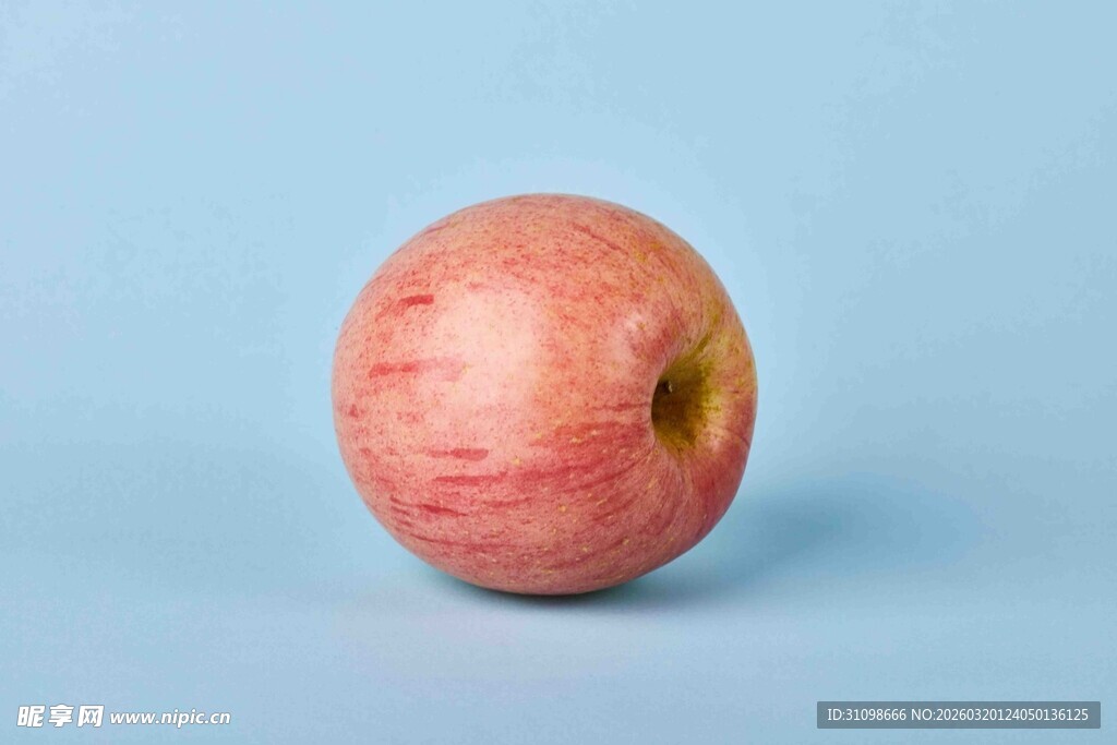 单个红苹果置于浅蓝色背景