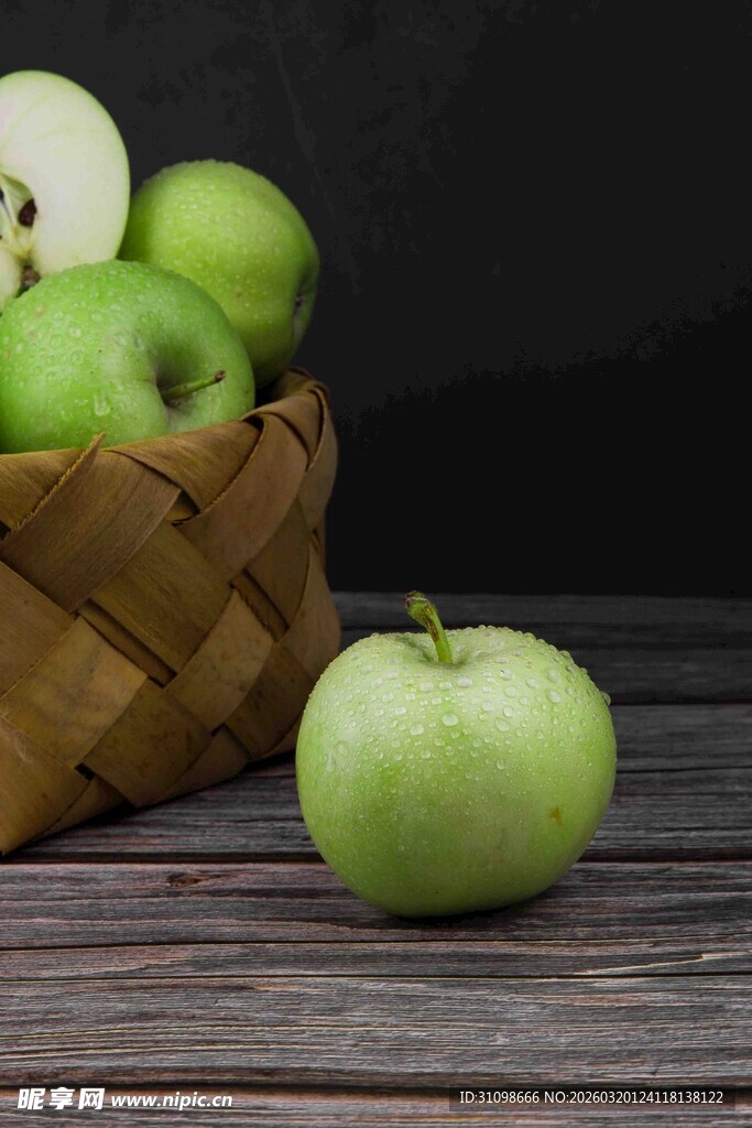 木桌上竹篮里的青苹果