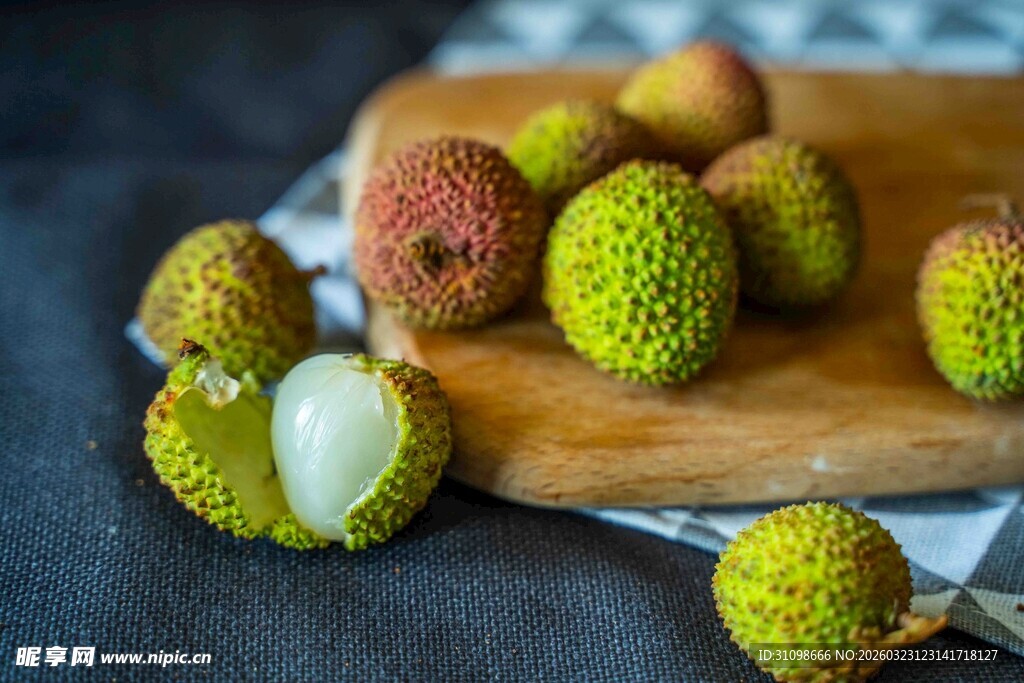 新鲜荔枝摆放在木砧板上