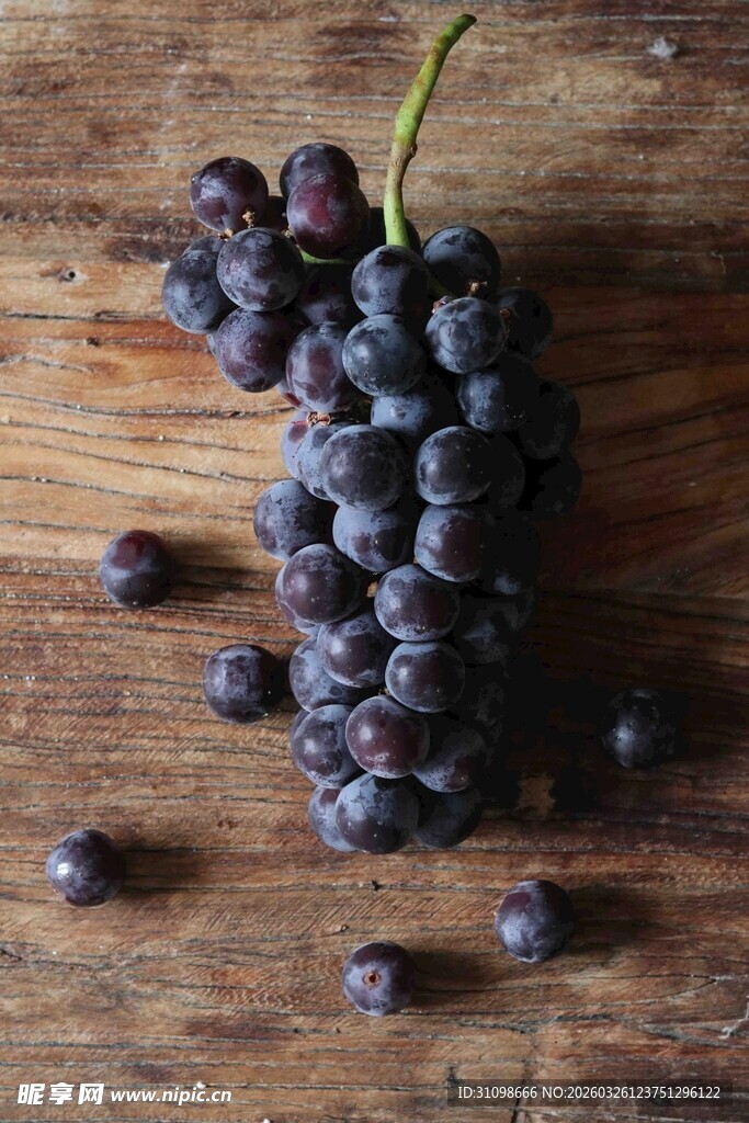 木桌上的紫黑葡萄浆果