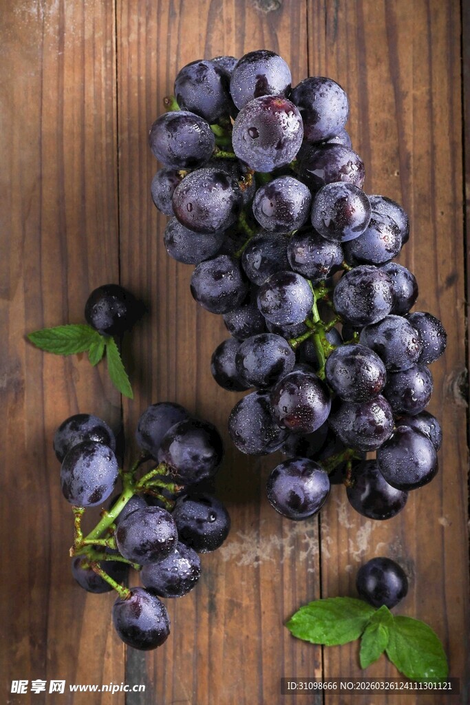 木桌上的紫葡萄与绿叶