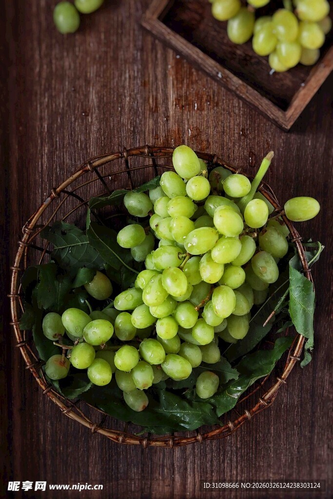 木桌上篮子里的鲜绿葡萄