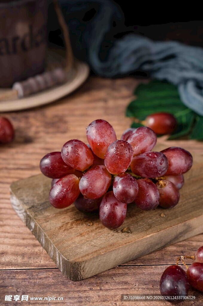 新鲜紫葡萄摆放在木砧板上