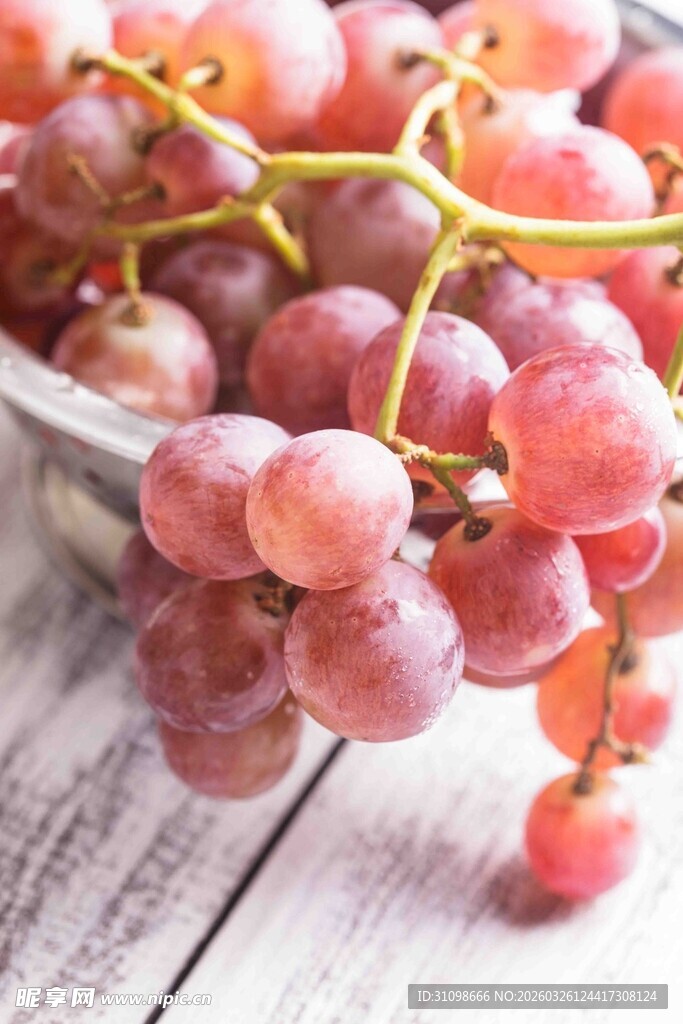 新鲜红葡萄摆于木桌之上