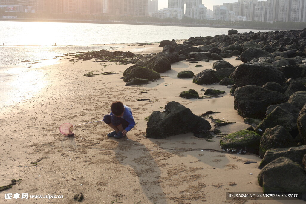 湛江海边孩童专注玩沙场景