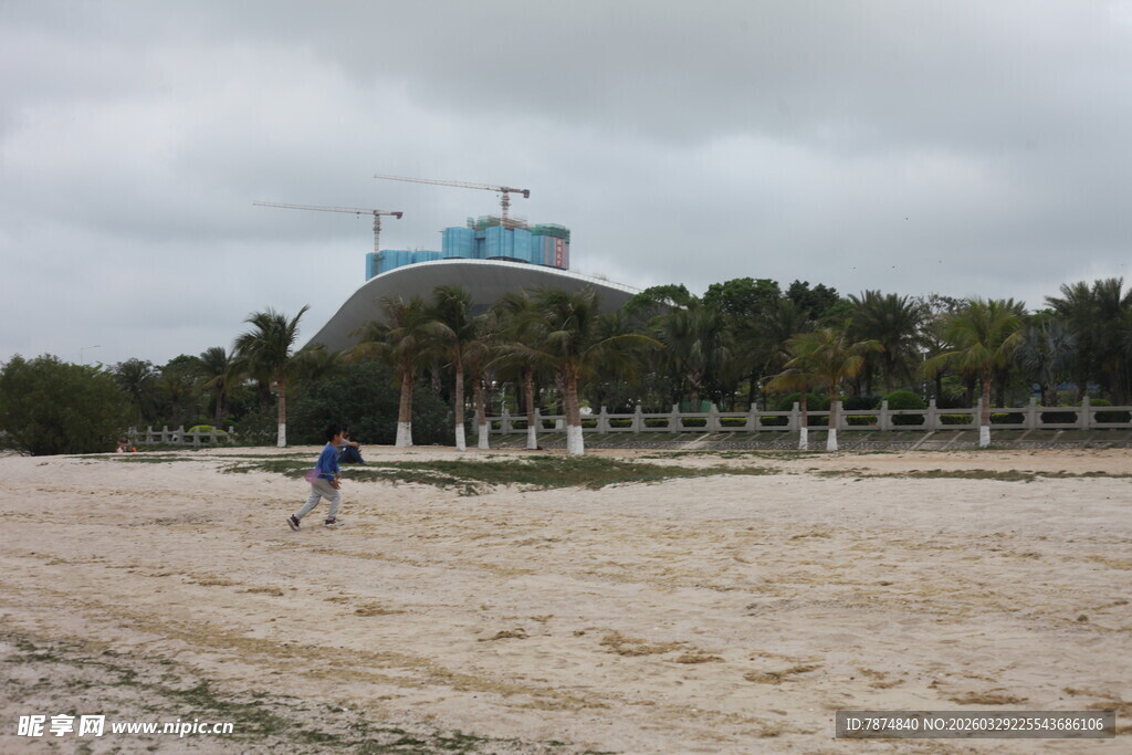 湛江沙滩上的行人与远方建筑