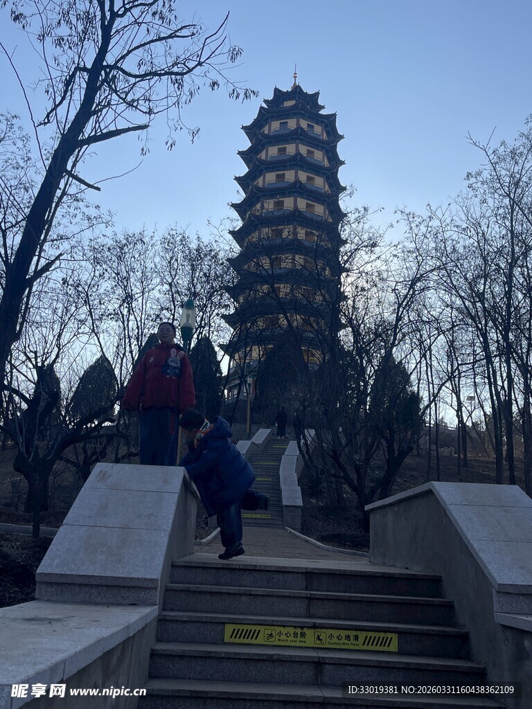 游客登台阶近观古塔