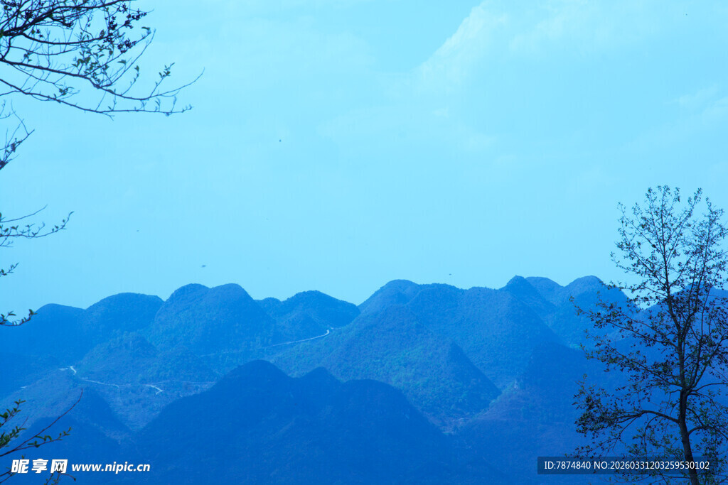 远山蓝天旁的稀疏树木