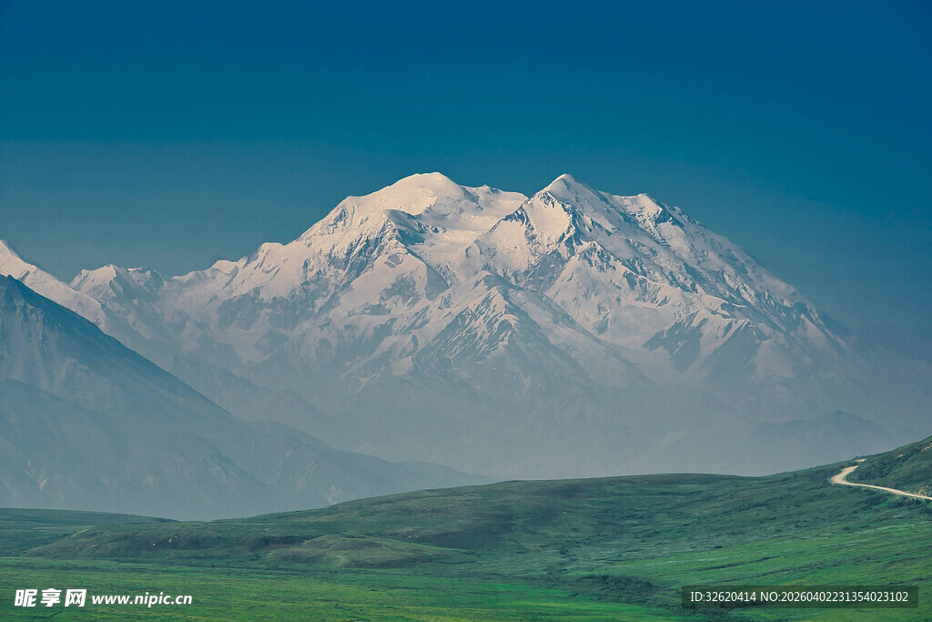 巍峨雪山下的广袤绿野